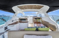 the interior of a boat with white furniture and pillows