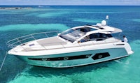 a white motor boat is floating in the ocean