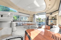 the interior of a boat with white couches and a dining table