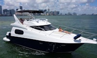 a white and black motor yacht in the water with people on it