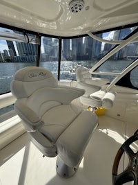 the interior of a boat with white seats and a view of the water