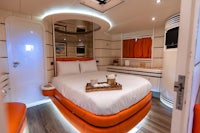 a room on a boat with a bed and a bedside table