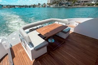 the deck of a boat with a table and chairs