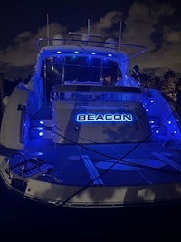 a boat is docked at night with blue lights on it