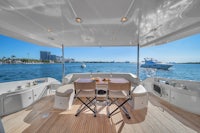 a white boat with a table and chairs on the deck