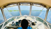 a woman is driving a boat on the water