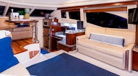 the interior of a motor yacht with blue couches and blue pillows