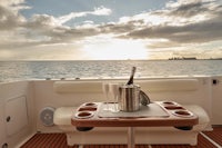 a table with a bottle of wine and a bottle of champagne on the deck of a boat