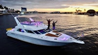 two people standing on a boat at sunset