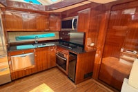 a kitchen on a boat with wood cabinets and stainless steel appliances