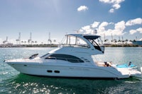 a white motor yacht in the water near a dock