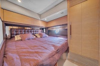 a bedroom on a yacht with a bed and a bedside table