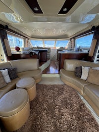 the interior of a boat with leather furniture and a skylight