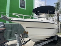 a white boat is parked in front of a green building