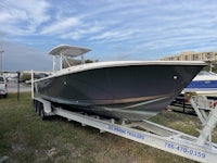 a boat is sitting on a trailer in a grassy area