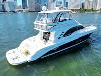 a white and blue boat in the water with a city in the background