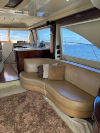 the interior of a boat with leather furniture and a view of the ocean