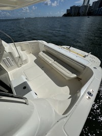 a white boat on the water with a city in the background