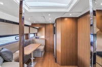 the interior of a boat with a kitchen and dining area