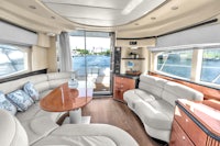 the interior of a boat with white couches and a table