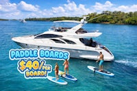 a group of people stand up paddle boarding on a boat