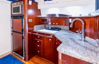 a kitchen on a boat with blue cabinets and granite counter tops