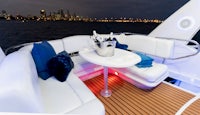 a white boat with a table and chairs at night