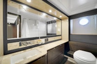 a bathroom with a toilet, sink and mirror