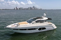 a motor boat in the water with a city in the background